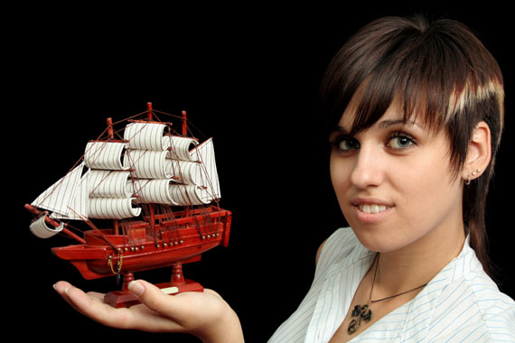 smiling girl holding a model sailing ship